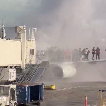 Avião da American Airlines pega fogo no aeroporto de Denver, e passageiros se aglomeram em asa